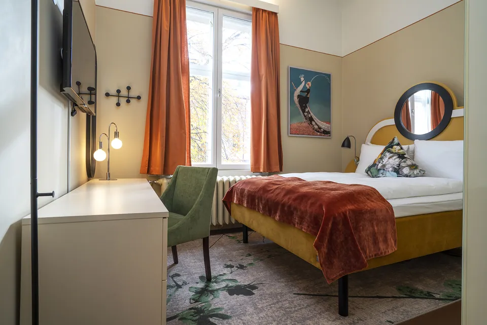 Leilighet i Josefines gate 30 med oransje gardiner og dobbeltseng